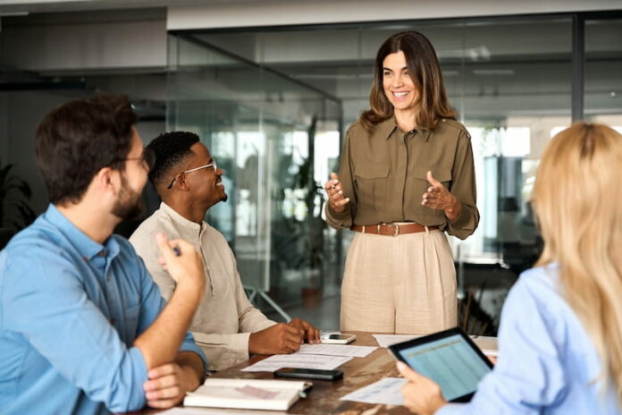 Eine People and Culture Managerin redet mit arbeitenden Beschäftigten und sorgt für gutes Arbeitsklima