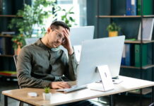 Bei der Beförderung übergangen werden: Tipps & Strategien für Betroffene Ein man sitzt traurig vor dem Computer, an seinem Arbeitsplatz. Er wurde bei Beförderung übergangen.