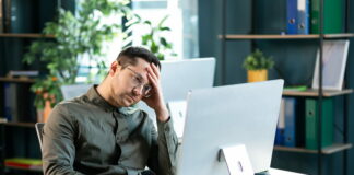 Bei der Beförderung übergangen werden: Tipps & Strategien für Betroffene Ein man sitzt traurig vor dem Computer, an seinem Arbeitsplatz. Er wurde bei Beförderung übergangen.