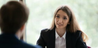 Austrittsgespräch: Nutze das Exit-Gespräch für einen positiven Abgang Eine Personalerin sitzt am Tisch und führt ein Austrittsgespräch mit einem Mitarbeiter., der ihr gegenübersitzt.