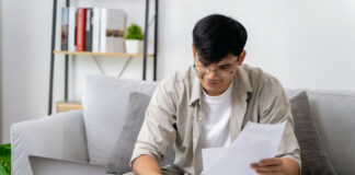 Werbungskosten: Dein Guide zur Steuererstattung – hol dir dein Geld zurück! Ein junger Arbeitnehmer sitzt vor seinem Laptop und gibt Werbungskosten bei seiner Steuererklärung an.